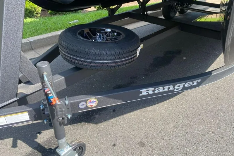 Slide: The Image of 2024 Ranger Reata 200C trailer with spare tire on asphalt road. - 11