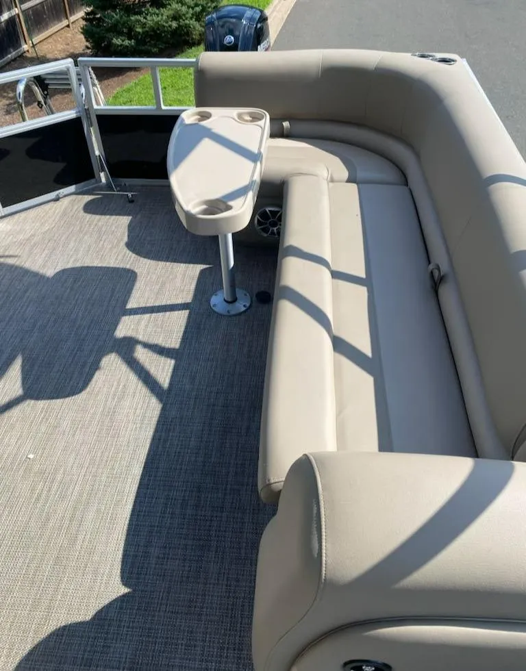 Slide: The Image of 2024 Ranger Reata 200C boat interior with beige seating and table. - 6