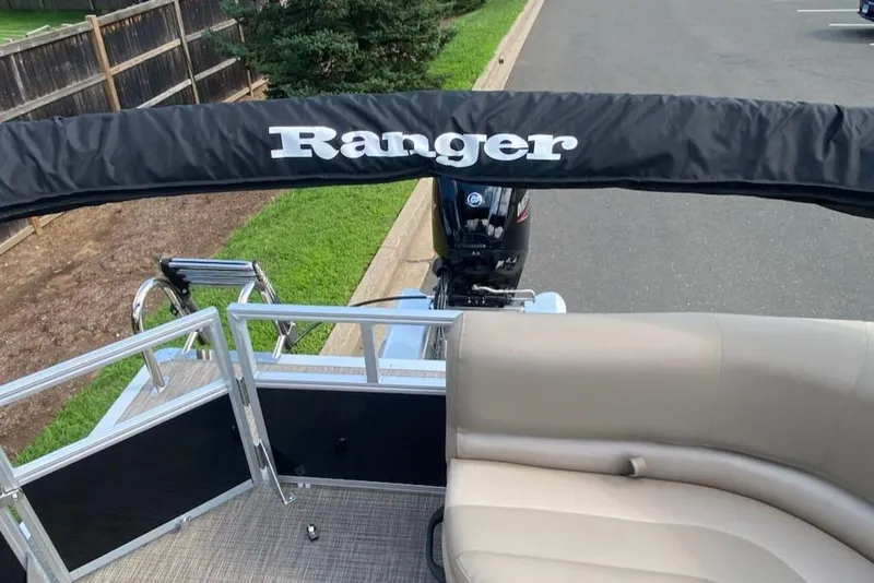 Slide: The Image of 2024 Ranger Reata 200C pontoon boat with beige seating and black canopy. - 8