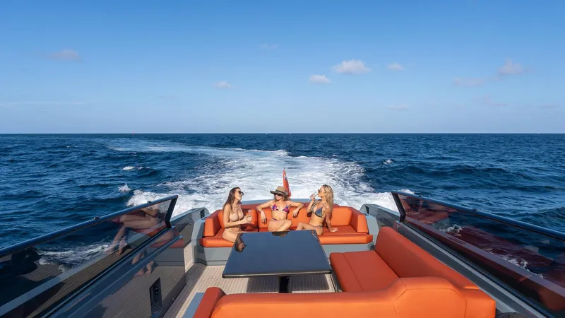 Slide: The Image of 2017 Vanquish Yachts VQ 54 cruising with passengers, featuring luxurious orange seating and ocean backdrop. - 7
