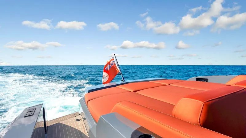 Slide: The Image of Vanquish Yachts VQ 54, 2017 model, cruising on open sea with red seating and flag. - 11