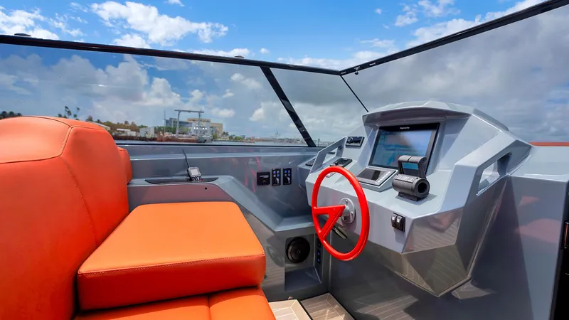 Slide: The Image of Interior of 2017 Vanquish Yachts VQ 54 with orange seating and modern dashboard. - 16