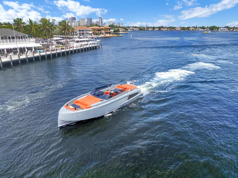 Slide: The Image of Vanquish Yachts VQ 54 (2017) cruising on a sunny waterfront with cityscape background. - 4