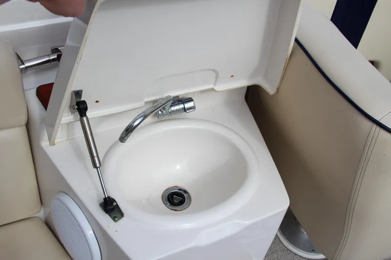 Slide: The Image of 2004 Chris-Craft Launch 25 boat sink with chrome faucet and beige seating. - 14