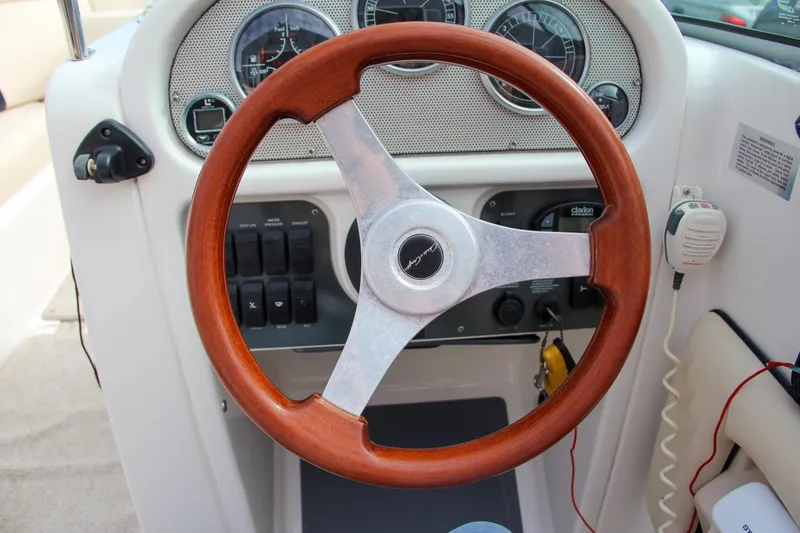 Slide: The Image of 2004 Chris-Craft Launch 25 dashboard with wooden steering wheel and instrument panel. - 20