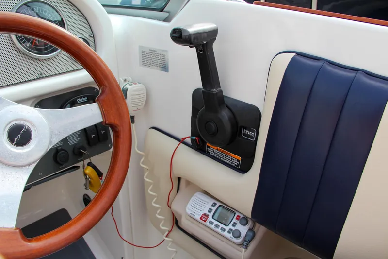 Slide: The Image of 2004 Chris-Craft Launch 25 boat dashboard with steering wheel and control panel. - 23
