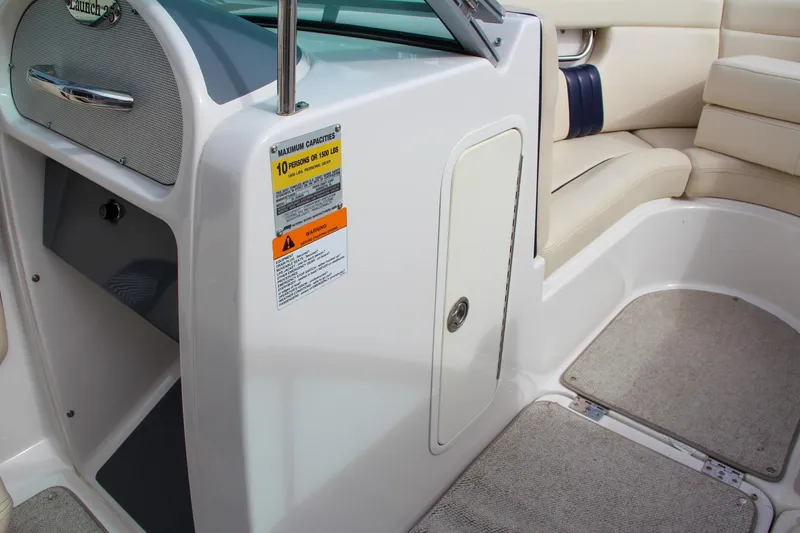 Slide: The Image of 2004 Chris-Craft Launch 25 interior with beige seating and storage compartment. - 25
