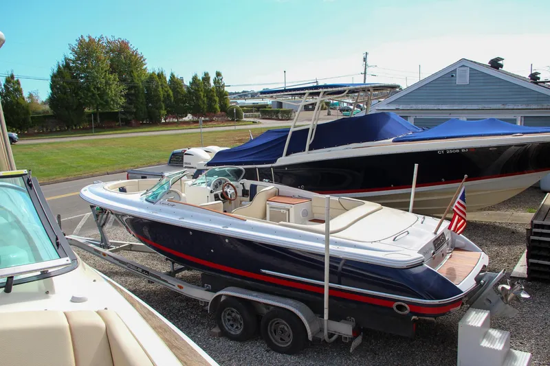 Slide: The Image of 2004 Chris-Craft Launch 25 boat on trailer, parked outdoors near other boats. - 45