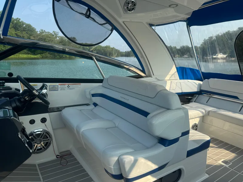 Slide: The Image of 2020 Formula 350 Crossover Bowrider interior with white seating and blue accents on a lake. - 15