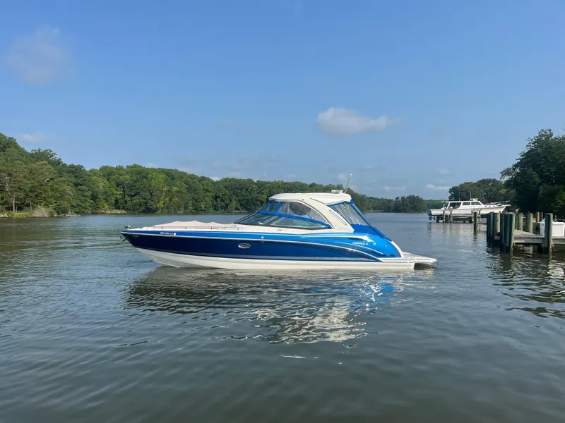 Slide: The Image of 2020 Formula 350 Crossover Bowrider on calm lake with lush green shoreline. - 2