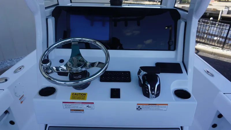 Slide: The Image of 2025 Sportsman 227 MASTERS boat dashboard with steering wheel and controls. - 14