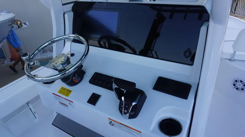 Slide: The Image of 2025 Sportsman 227 MASTERS boat dashboard with steering wheel and controls. - 16