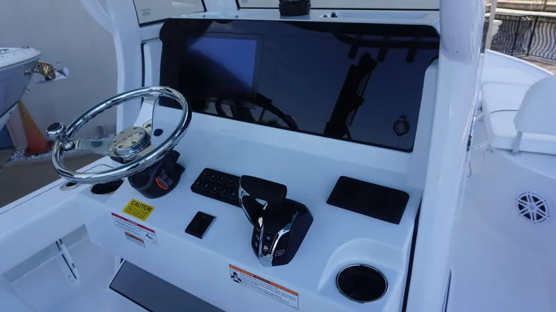 Slide: The Image of 2025 Sportsman 227 MASTERS boat console with steering wheel and controls. - 17