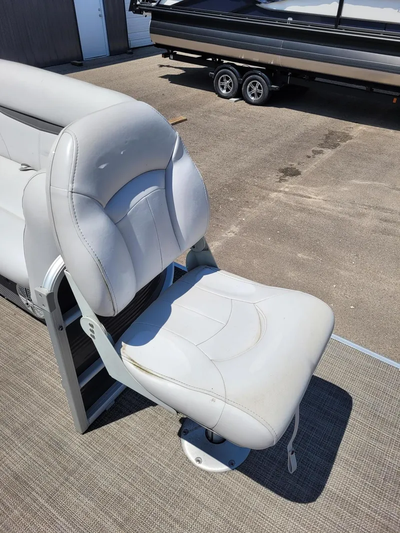Slide: The Image of White boat seat on Sweetwater SW2286BF, 2018 model, with trailer in background. - 11