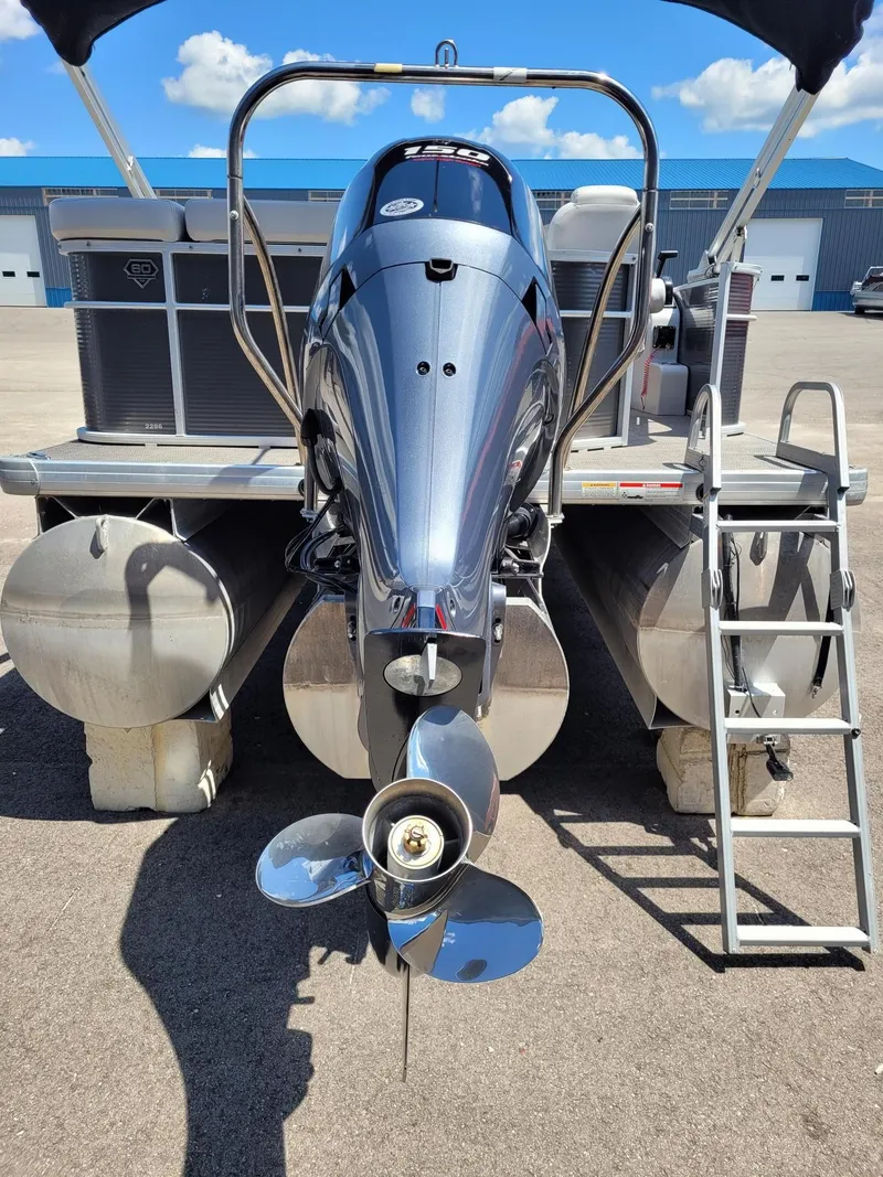 Slide: The Image of Sweetwater SW2286BF 2018 pontoon boat with outboard motor and ladder, parked on concrete. - 3