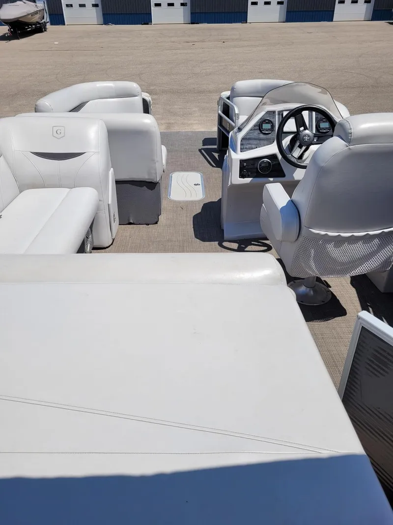Slide: The Image of Interior of a 2018 Sweetwater SW2286BF pontoon boat with white seating and steering console. - 5