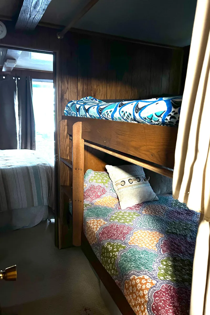 Slide: The Image of Bunk beds in a 1988 Waterhouse houseboat with colorful bedding and wooden interior. - 13