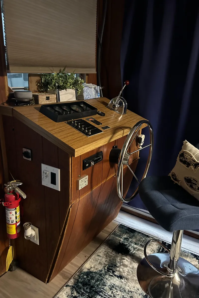 Slide: The Image of 1988 Waterhouse houseboat helm with steering wheel, control panel, and stool. - 4