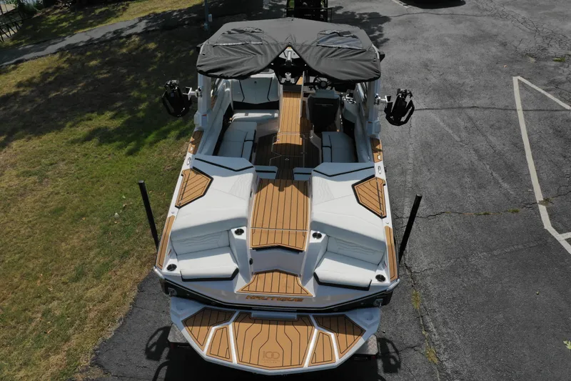Slide: The Image of 2025 Nautique G23 boat with sleek design and wooden deck accents. - 10