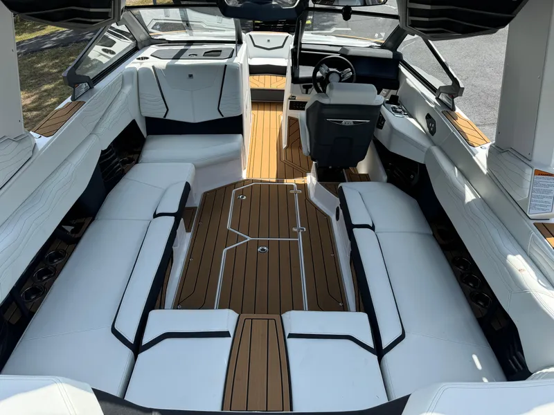 Slide: The Image of 2025 Nautique G23 boat interior with white seating and wood accents. - 16