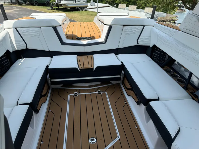Slide: The Image of 2025 Nautique G23 boat interior with luxurious seating and teak flooring. - 17