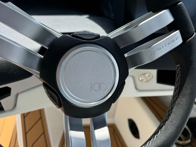 Slide: The Image of Steering wheel of 2025 Nautique G23 boat, featuring sleek metallic design. - 20