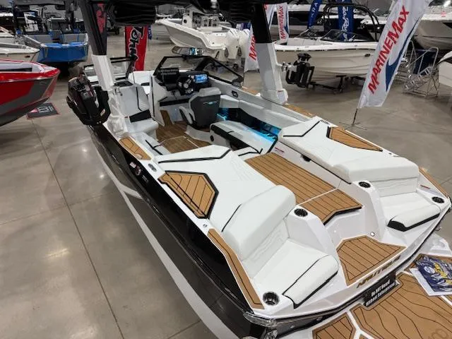 Slide: The Image of 2025 Nautique G23 boat with sleek design and modern interior at a showroom display. - 24