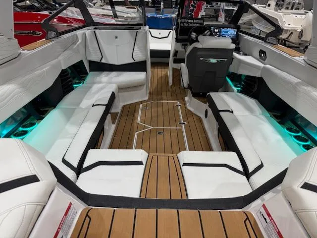 Slide: The Image of 2025 Nautique G23 boat interior with white seating and ambient lighting. - 26