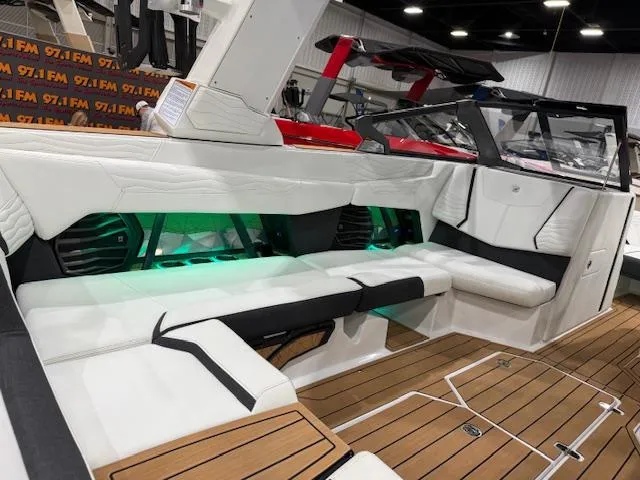 Slide: The Image of 2025 Nautique G23 boat interior with white seating and green LED lighting. - 27