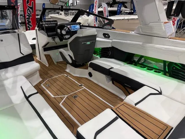 Slide: The Image of 2025 Nautique G23 boat interior with sleek design, white seating, and wood flooring. - 28