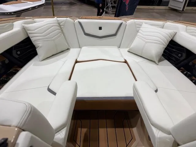Slide: The Image of 2025 Nautique G23 boat interior with white cushioned seating and wooden flooring. - 29