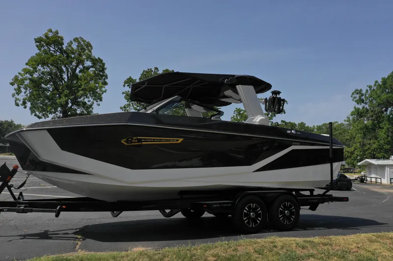 Slide: The Image of 2025 Nautique G23 boat on trailer, parked outdoors, side view. - 6
