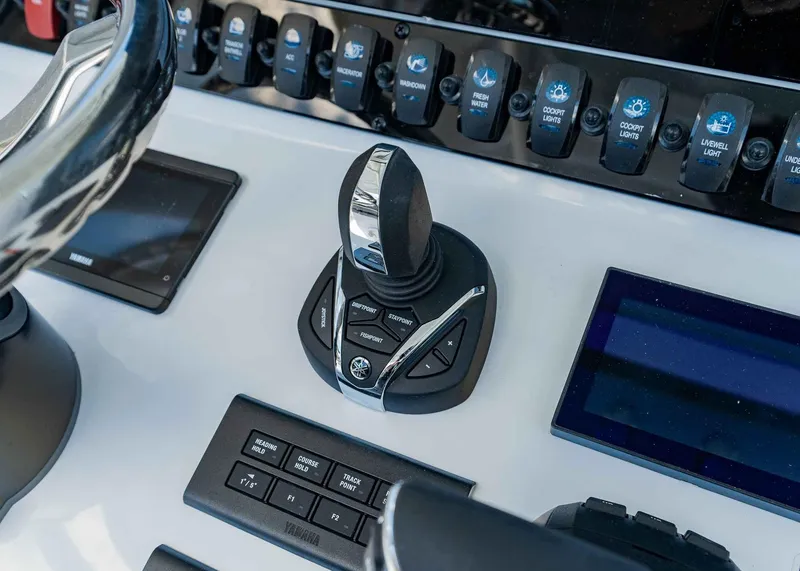 Slide: The Image of Control panel of 2025 Sea Hunt Ultra 305 SE boat with joystick and switches. - 18