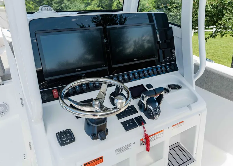 Slide: The Image of 2025 Sea Hunt Ultra 305 SE boat dashboard with dual screens and steering wheel. - 20