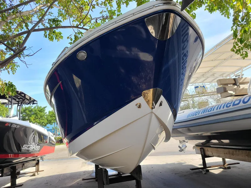 Slide: The Image of 2016 Chaparral 307 SSX boat on display, blue hull, outdoor setting. - 1