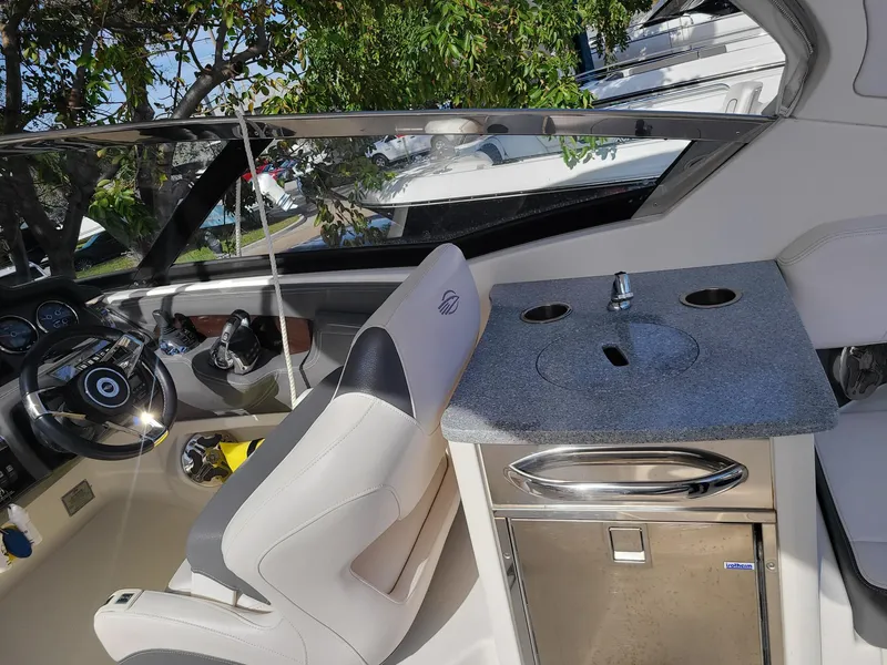 Slide: The Image of 2016 Chaparral 307 SSX boat interior with helm and kitchenette. - 12