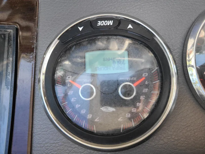 Slide: The Image of Close-up of a 2016 Chaparral 307 SSX boat tachometer gauge displaying RPM and mode button. - 16