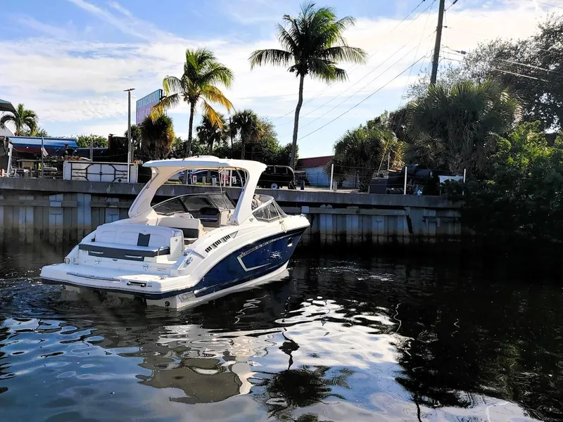 Slide: The Image of 2016 Chaparral 307 SSX boat docked near palm trees on a sunny day. - 3
