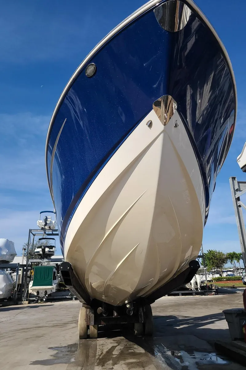 Slide: The Image of 2016 Chaparral 307 SSX boat on trailer, blue and white hull, sunny day. - 5