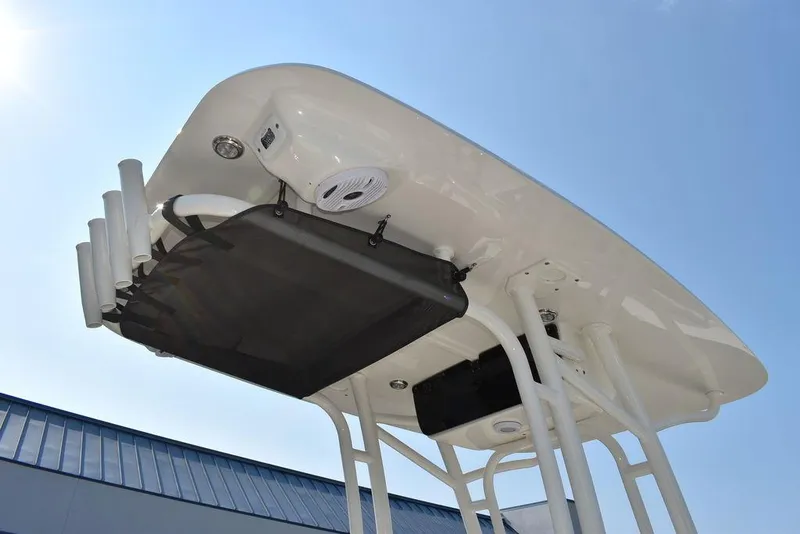 Slide: The Image of 2024 Key West 203 FS boat T-top with rod holders and speaker, under clear sky. - 15