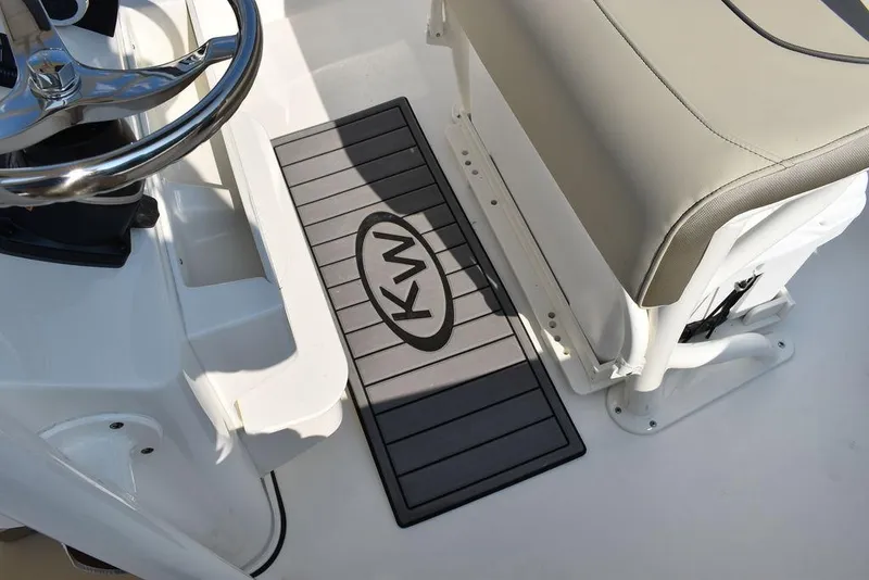 Slide: The Image of 2024 Key West 203 FS boat interior with KW logo mat and steering wheel. - 48