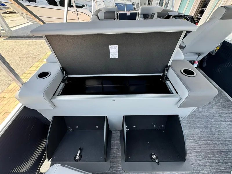 Slide: The Image of 2025 Bennington 22ss-sps boat interior with open storage compartments and cup holders. - 12