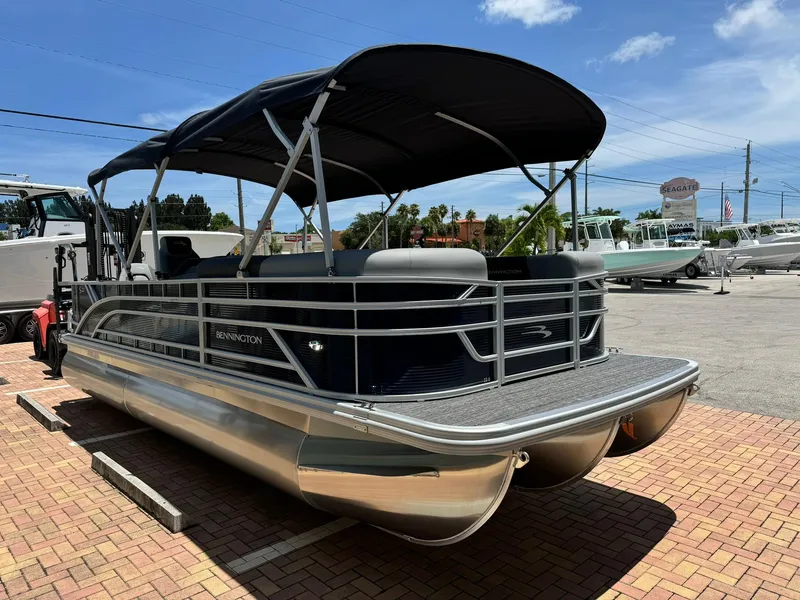Slide: The Image of 2025 Bennington 22ss-sps pontoon boat with black canopy on display outdoors. - 3