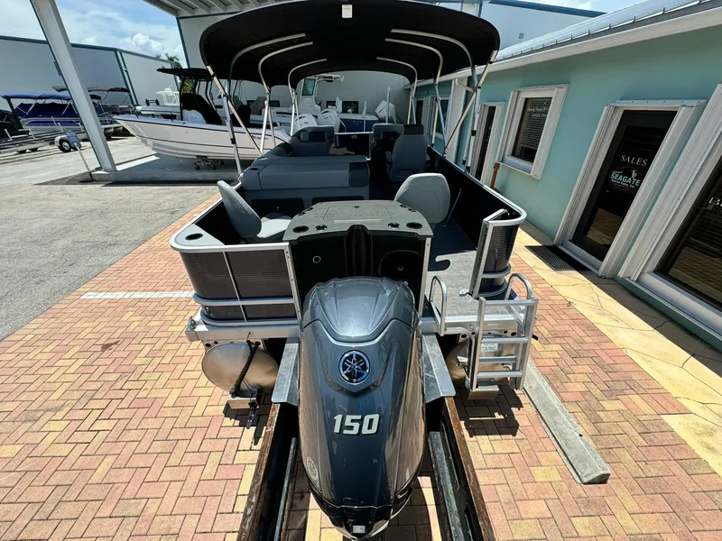Slide: The Image of 2025 Bennington 22ss-sps pontoon boat with Yamaha 150 engine, docked on brick pavement. - 5