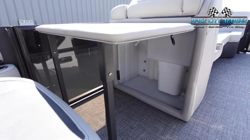 Slide: The Image of 2025 Barletta C24UC pontoon boat interior with foldable table and storage compartment. - 31