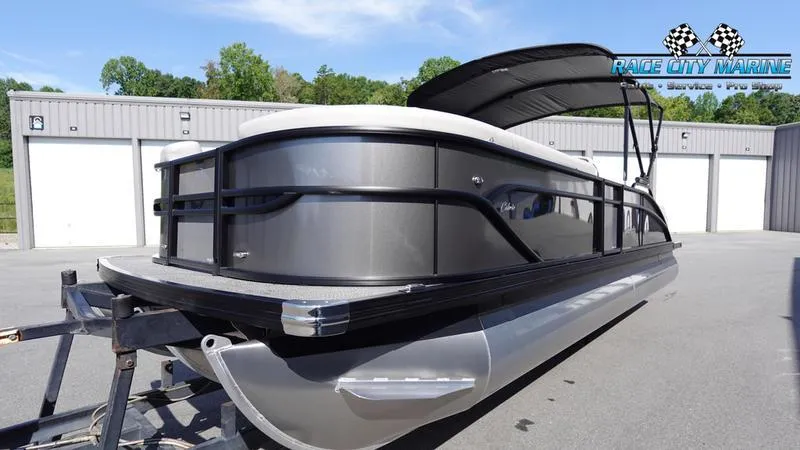 Slide: The Image of 2025 Barletta C24UC pontoon boat with sleek design, parked outdoors. - 6