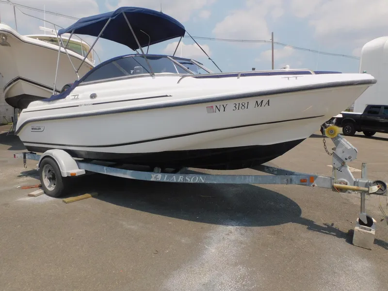 Slide: The Image of 2004 Boston Whaler Ventura 180 boat on trailer with blue canopy. - 1