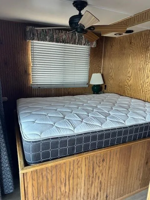 Slide: The Image of Cozy bedroom in 1994 Lakeview model 1666 with wooden paneling and ceiling fan. - 5