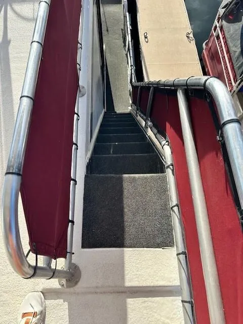 Slide: The Image of Staircase on a 1994 Lakeview 1666 boat with red railings and carpeted steps. - 7