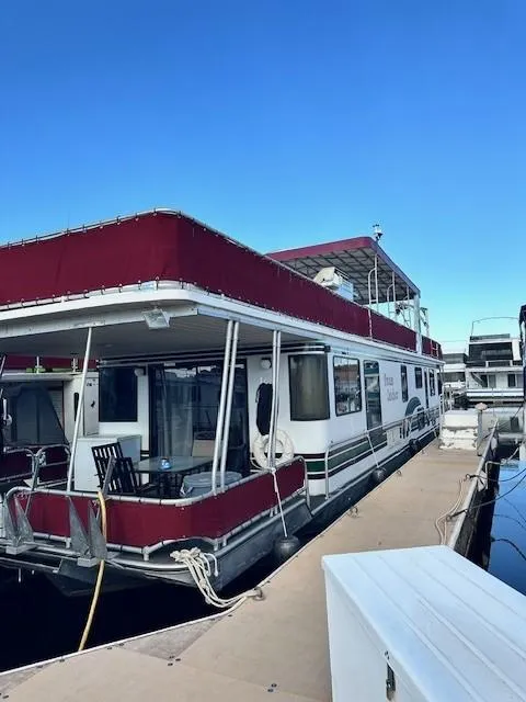 Slide: The Image of Houseboat docked at marina, Lakeview 1666 model, 1994, with red canopy and outdoor seating. - 9